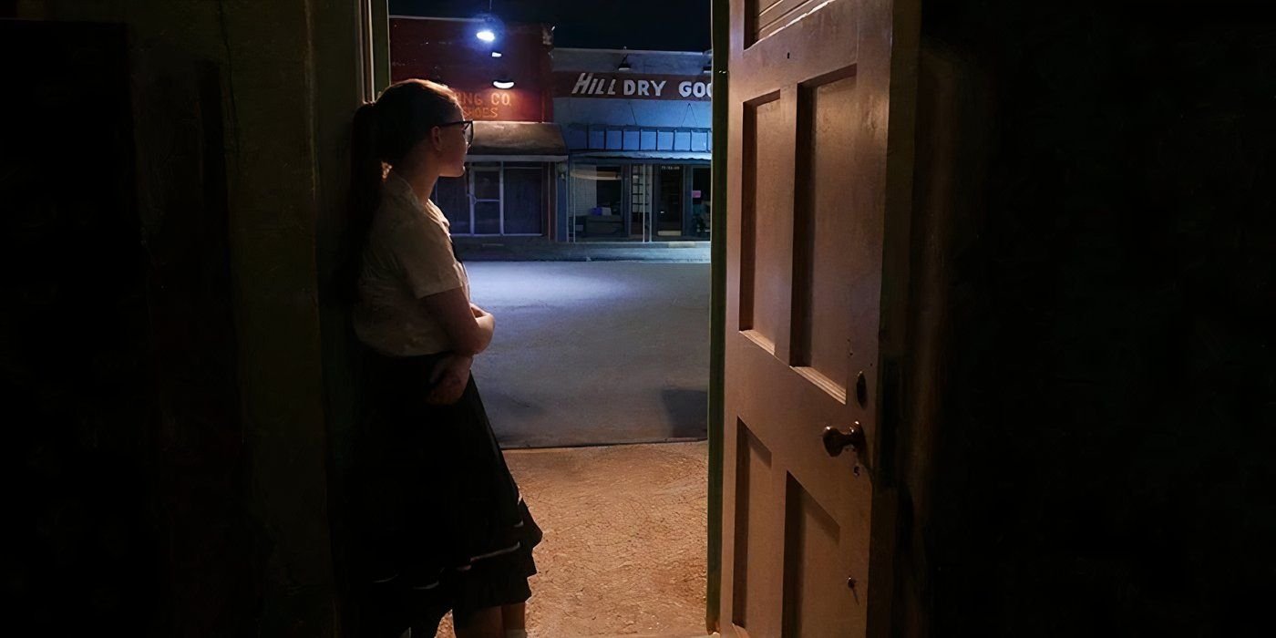 a girl stands in a doorway in the vast of night