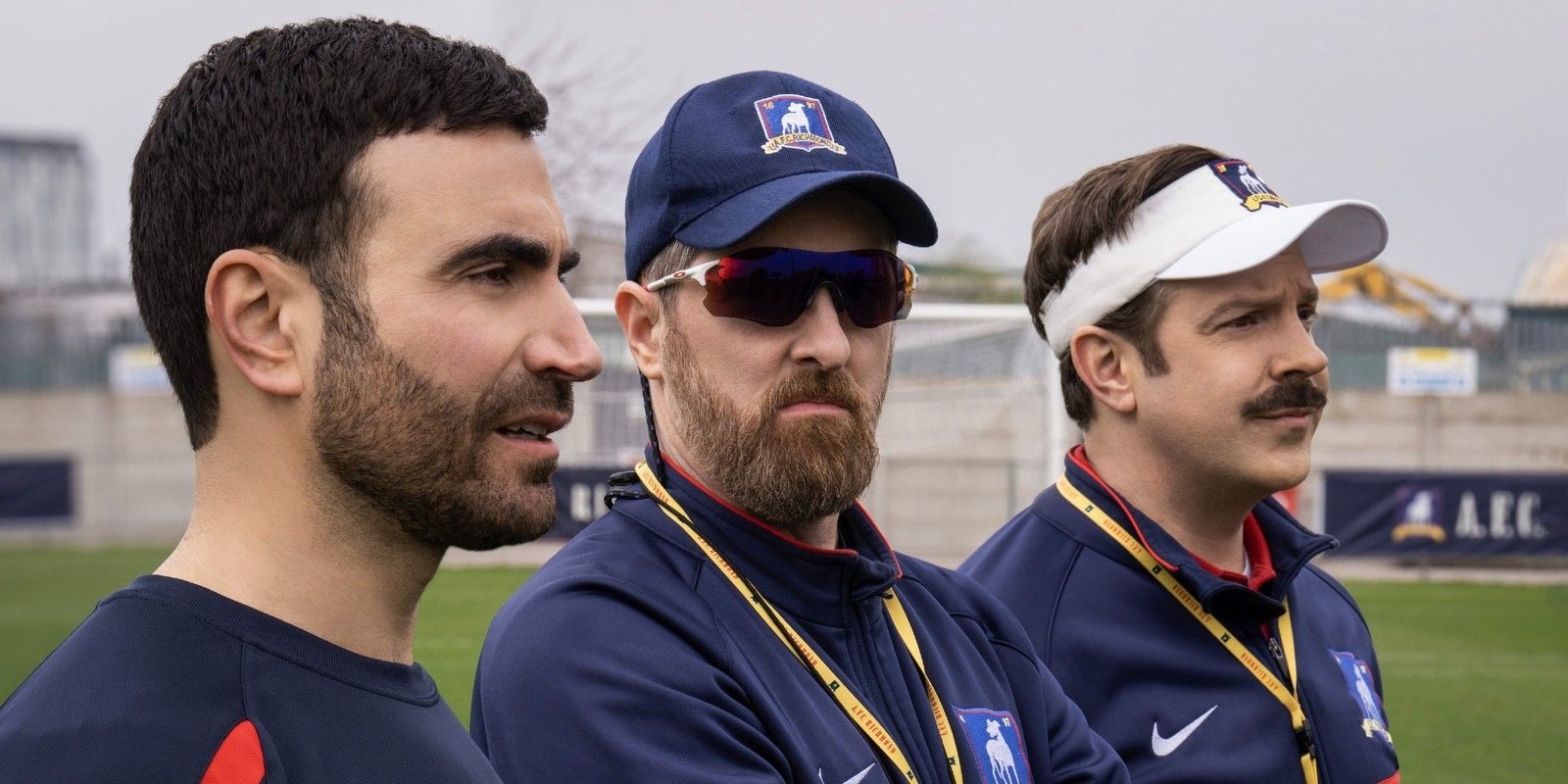 Roy, Ted, and Beard look over the soccer pitch in Ted Lasso